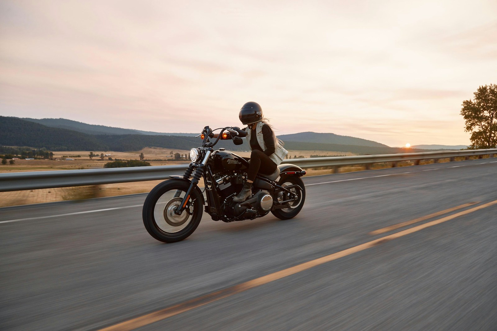 woman on black cruiser motorcycle in highway